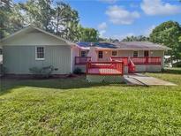 Lovely backyard featuring a red deck, spacious green grass and lush trees, perfect for outdoor entertaining at 5142 Golfbrook Ct, Stone Mountain, GA 30088