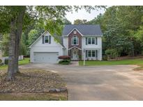 Charming two-story home features a two-car garage, well-manicured lawn, and a classic white and brick facade at 2101 Emerald Dr, Loganville, GA 30052