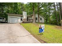 Inviting single Gathering home featuring a charming front porch and lush, mature landscaping at 3963 Ferncliff Rd, Snellville, GA 30039