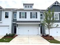 Charming townhome featuring a white brick facade and a two-car garage at 1958 Asher Ln # 50, Conyers, GA 30013