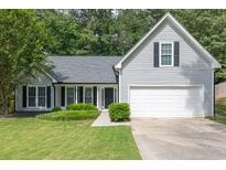 Charming one-story home with two-car garage, lush lawn, and mature trees at 620 Alcovy Springs Dr, Lawrenceville, GA 30045