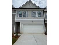 Charming two-story townhome with a gray color scheme, attached garage, and a well-maintained lawn at 1023 Merritt Dr # 100, Villa Rica, GA 30180