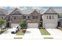 Charming brick townhomes with attached garages and well-manicured lawns present a welcoming curb appeal at 2924 Weyhill Trl, Buford, GA 30519