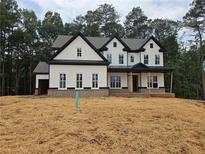 Charming two-story home boasts a classic black and white design, complemented by lush surrounding trees at 3425 Dr Bramblett Rd, Cumming, GA 30028