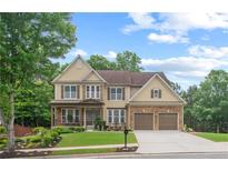 Beautiful two-story home with a well-manicured lawn and mature trees, creating a welcoming curb appeal at 155 Edgewater Trl, Canton, GA 30115