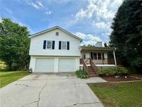 Charming two-story home featuring a front porch, two-car garage, and neat landscaping at 23 Jennifer Ln, Rydal, GA 30171