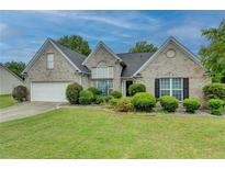 Charming one-story brick home featuring a well-manicured lawn and attached two-car garage at 3865 Portico Run Dr, Buford, GA 30519