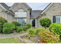 Charming brick home with a well-manicured front yard and lush landscaping at 3865 Portico Run Dr, Buford, GA 30519