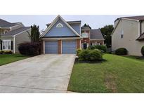 Charming two-story home featuring a well-manicured lawn, a two-car garage, and attractive curb appeal at 13030 Crabapple Lake Dr, Roswell, GA 30076