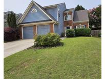 Charming two-story home with a well-manicured lawn and an attached two-car garage at 13030 Crabapple Lake Dr, Roswell, GA 30076