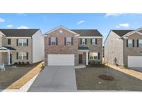 Charming two-story brick home with a two-car garage and well-maintained front yard at 1483 Autumn Wind Dr, Dacula, GA 30019