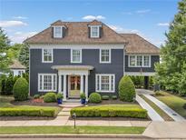 Charming two-story home featuring a manicured lawn and elegant architectural details, including dormer windows at 6815 Berkley Rd, Cumming, GA 30040
