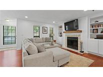 Inviting living room with a large sectional sofa, fireplace, TV, and built-in bookshelves at 2808 Vinings Central Se Dr # 158, Atlanta, GA 30339