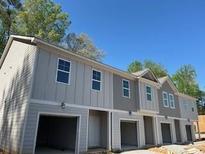 Gray two-story townhome boasts a one-car garage and neutral trim at 4263 Notting Hill Sw Dr, Atlanta, GA 30331