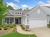 Charming single-Gathering home featuring a two-car garage and beautifully landscaped front yard at 215 Windsor Park Dr, Woodstock, GA 30188