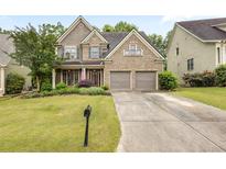 Charming two-story brick home featuring a well-manicured lawn, mature trees, and a two-car garage at 1839 Tranquil Field Nw Dr, Acworth, GA 30102