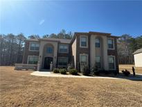 Stately brick home featuring manicured landscaping and elegant architectural details on a sunny day at 2709 Ratby Ne Ln, Conyers, GA 30013