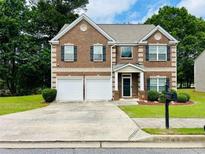Charming brick two-story home with a well-manicured lawn and a two-car garage at 5848 Rex Ridge Loop, Rex, GA 30273