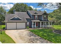 Charming two-story home with a well-manicured lawn, a two-car garage, and a welcoming front porch at 2505 Se Tiffany Ct, Conyers, GA 30013