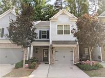 Charming townhome with brick accents, neutral siding, a well-manicured lawn and an attached one car garage at 2508 Norwood Park Xing, Atlanta, GA 30340