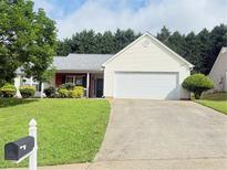 Charming home with a well-manicured lawn and inviting curb appeal on a sunny day at 3484 Lynley Mill Ln, Dacula, GA 30019