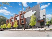 Modern townhome with sleek gray siding, balconies, and a black iron fence enhancing curb appeal at 367 Parkway Ne Dr # 6, Atlanta, GA 30312