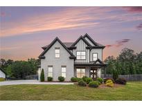 Beautiful two-story home with a brick facade, black trim, a well-manicured lawn, and professional landscaping at 1660 Chandler Rd, Lawrenceville, GA 30045
