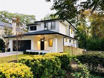 Beautifully landscaped home boasts a two-story facade, a black garage door, and a welcoming front porch at 206 Mead Rd, Decatur, GA 30030