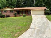 Charming single-story brick home with well-manicured lawn, mature trees, and long driveway at 3190 Cheru Ct, Decatur, GA 30034