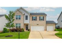 Charming two-story home with a brick facade, three-car garage, manicured lawn and inviting front door at 5025 Bryce Ln, Cumming, GA 30040