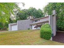 Stunning two-story home showcasing a well-manicured lawn and inviting curb appeal in a serene, wooded setting at 6010 Spalding Dr, Atlanta, GA 30350