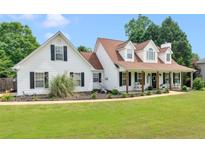 Charming two-story home featuring a welcoming front porch and well-maintained landscaping with black shutters and a lush green lawn at 710 Freeman Dr, Covington, GA 30016