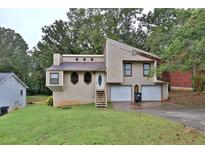 Charming home featuring a two-car garage, unique window design, and a welcoming front yard at 2715 Cordite Loop, Snellville, GA 30039