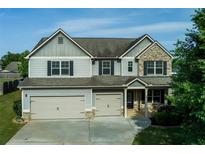 Charming two-story home with a two-car garage and beautifully manicured lawn at 9120 Alden Dr, Locust Grove, GA 30248