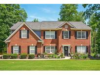 Beautiful two-story brick home with well-manicured lawn and front garden at 100 Chadwick Pl, Villa Rica, GA 30180