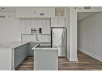 Modern kitchen features stainless steel appliances, gray cabinets, and a stylish island cooktop at 57 Forsyth Nw St # 14B, Atlanta, GA 30303