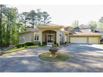 Stunning home features a circular driveway and beautifully landscaped front yard with an elegant fountain at 1010 Forest Overlook Sw Dr, Atlanta, GA 30331