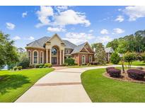 Stunning brick home featuring a manicured front yard, a long driveway, and beautiful architectural details at 179 Worthington Way, Jonesboro, GA 30236