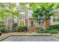 Charming townhome featuring a brick facade, manicured landscaping, and a welcoming entrance framed by lush greenery at 248 Riverview Trl, Roswell, GA 30075