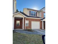 Charming brick townhome featuring an attached garage and inviting covered entryway at 2572 Laurel Cir, Atlanta, GA 30311
