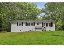 Charming one-story home with black shutters, landscaped yard and inviting entry at 2765 Ocean Valley Dr, Atlanta, GA 30349