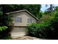 Two story home featuring a 2-car garage and neutral siding surrounded by lush greenery at 3530 Terri Lynn Ct, Tucker, GA 30084