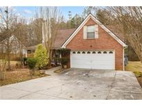 Charming brick home with a two-car garage and a well-maintained front yard and driveway at 105 Hunters, Mcdonough, GA 30253