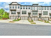 A stunning exterior view of modern townhomes, each featuring a private garage and inviting entryways at 1122 Provence Ln, Decatur, GA 30033