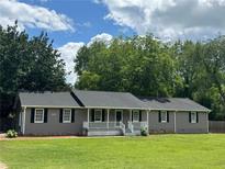 Charming single-story home with well-maintained lawn and inviting front porch and newly painted gray siding at 1810 King Mill Rd, Mcdonough, GA 30252