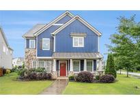 Charming two-story home with blue siding and stone accents, complemented by a lush front yard at 1946 Jeffery Nw Rd, Atlanta, GA 30318