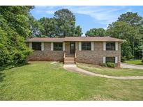 Charming brick home with a well-manicured lawn and inviting front entrance at 530 Village Green Sw Ct, Lilburn, GA 30047