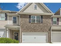 Charming two-story townhome with brick facade, gray siding, and a two-car garage at 3070 Fareed St, Douglasville, GA 30135