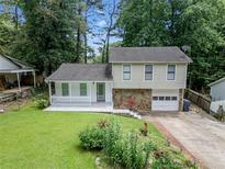 Charming two-story home featuring a well-maintained lawn, stone accents, a covered porch, and an attached garage at 3227 Fescue Cir, Lawrenceville, GA 30044