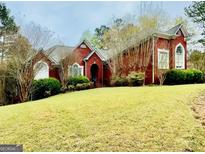 Beautiful brick home with a well-manicured lawn and charming architectural details at 1090 Crown River Pkwy, Mcdonough, GA 30252